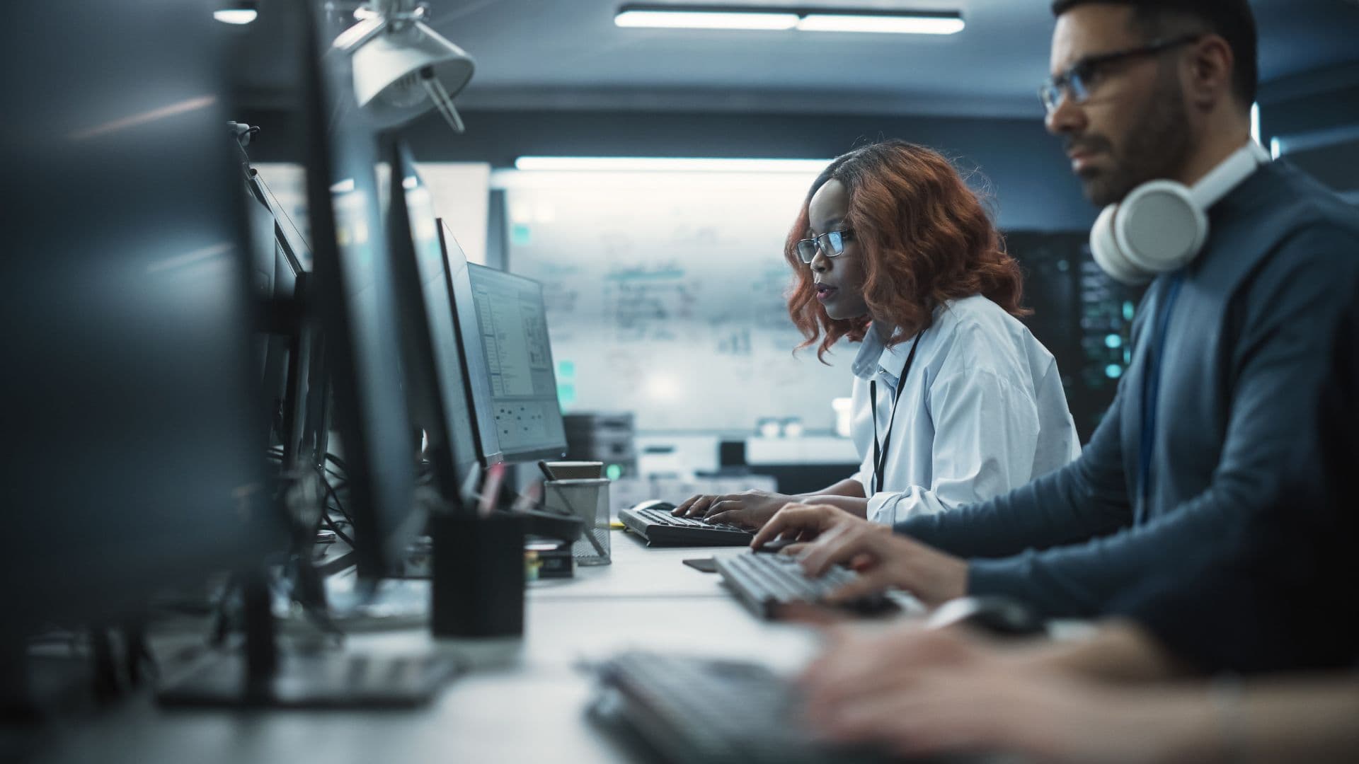 Clean‑tech professionals working on computers to plan and deliver renewable energy projects, highlighting workforce skills gaps impacting clean tech strategy and execution.