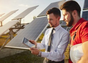 Solar technicians installing a photovoltaic panel on a rooftop