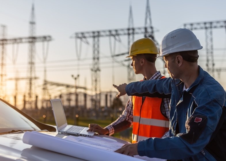 Man working in the renewable energy sector inspecting solar panels in an outdoor installation.