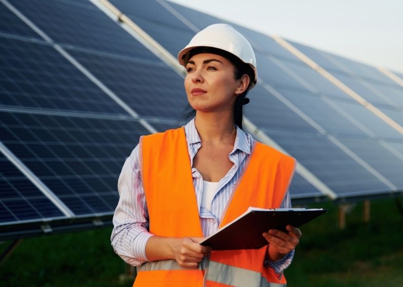 Women clean tech professionals working with solar panels at a solar energy site in Europe.