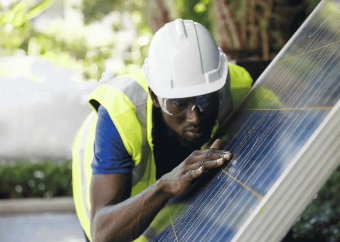 A clean tech employee inspecting solar panels at a renewable energy facility.