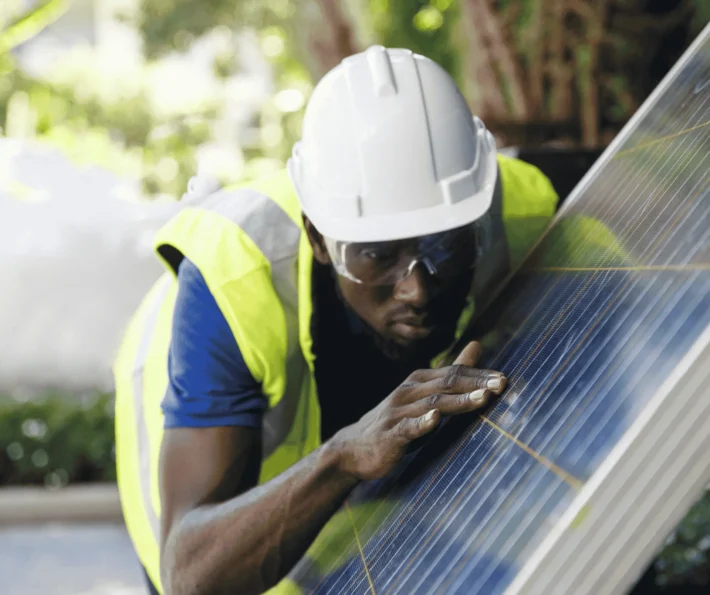 A clean tech employee inspecting solar panels at a renewable energy facility.